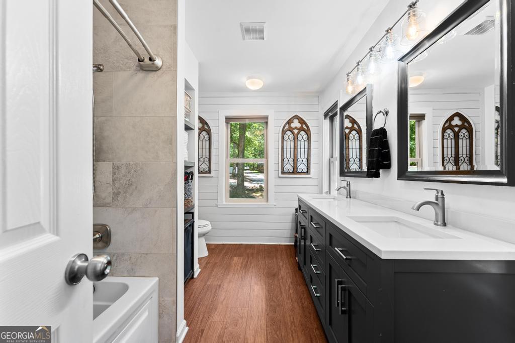 585 John Fleming Road Hartwell, GA 30643 - Photo 31 of 59 a bathroom with a double vanity sink a mirror a window and a shower