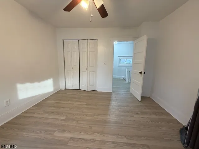 wooden floor in an empty room with a bathroom