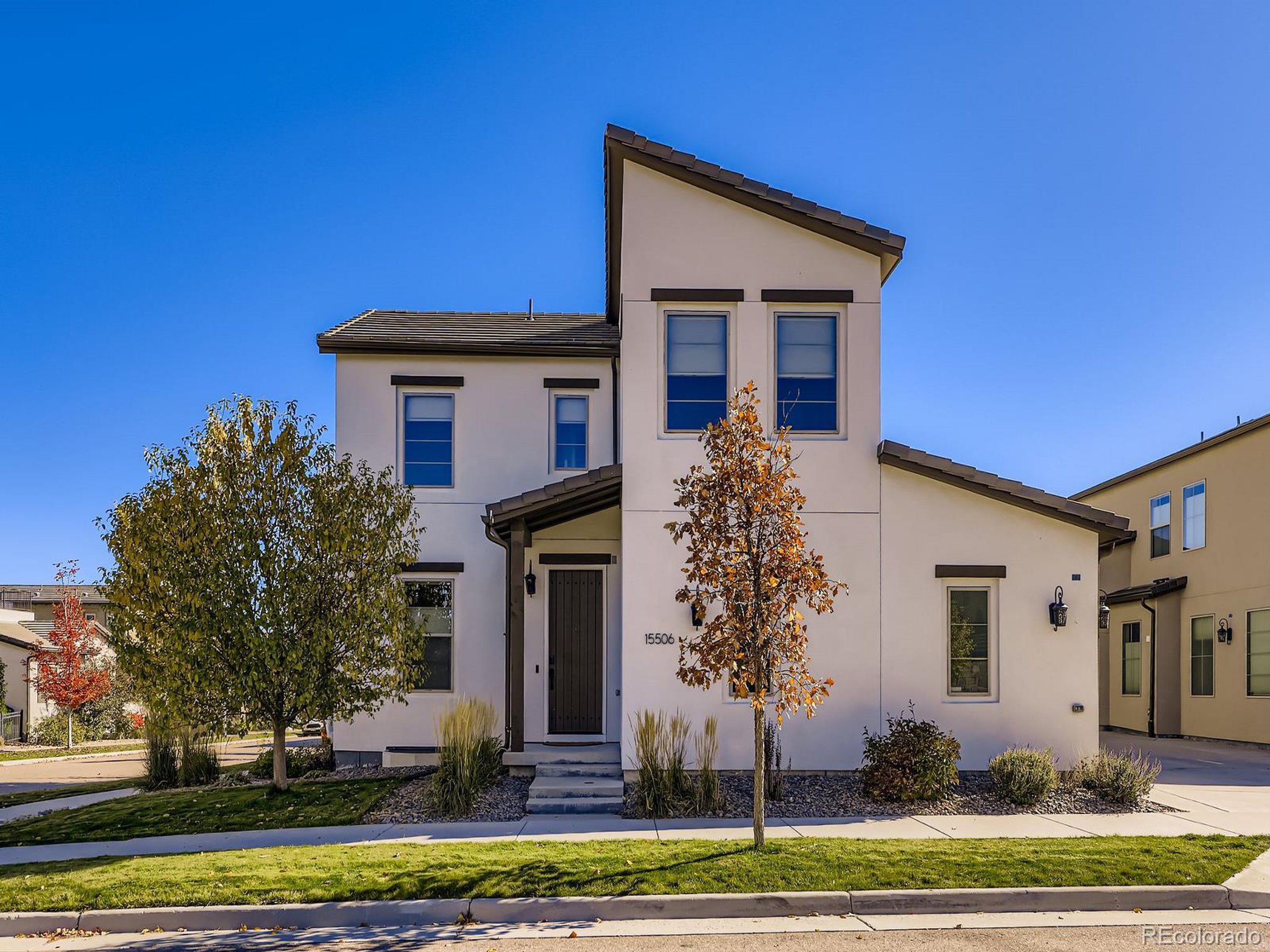 15506 W Lane Lakewood, CO 80228 - Photo 1 of 37 a front view of a house with a yard garage and trees