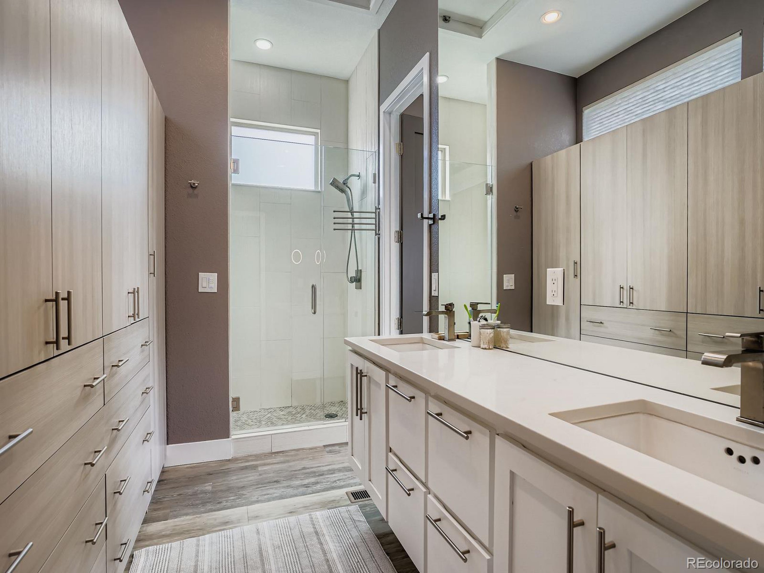 15506 W Lane Lakewood, CO 80228 - Photo 15 of 37 a spacious bathroom with a double vanity sink a mirror and a shower