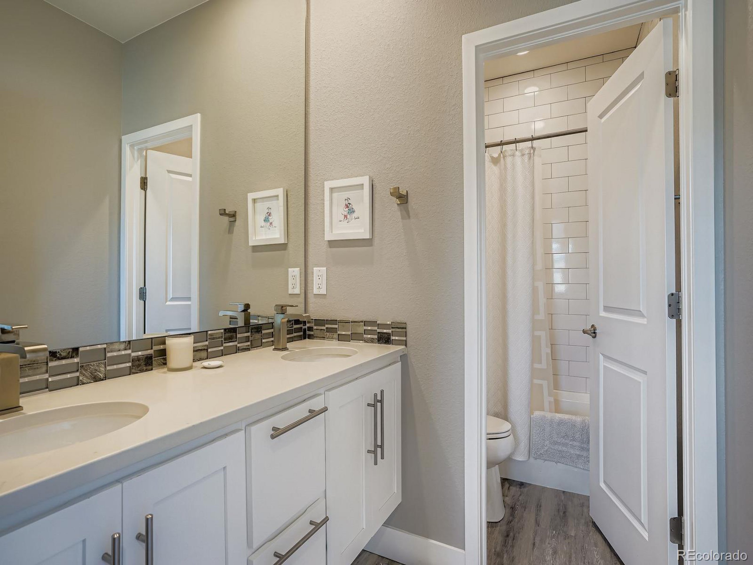 15506 W Lane Lakewood, CO 80228 - Photo 23 of 37 a bathroom with a granite countertop sink and a mirror