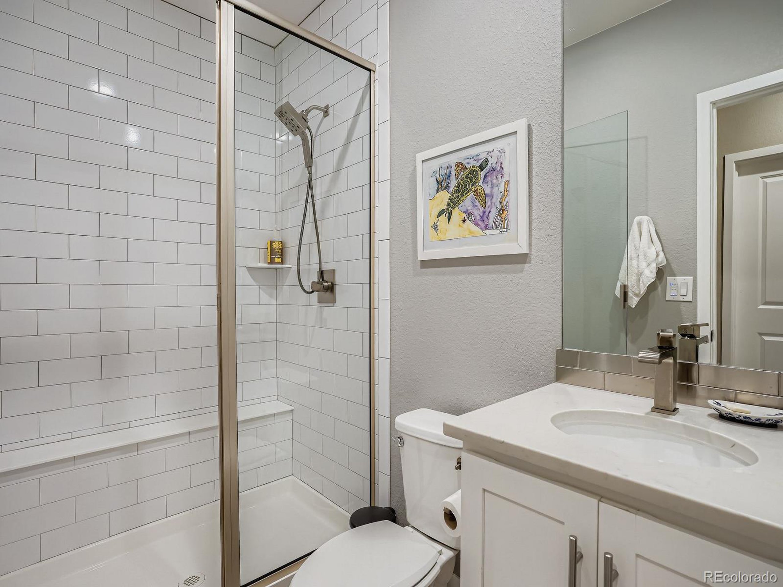 15506 W Lane Lakewood, CO 80228 - Photo 28 of 37 a bathroom with a sink toilet and shower