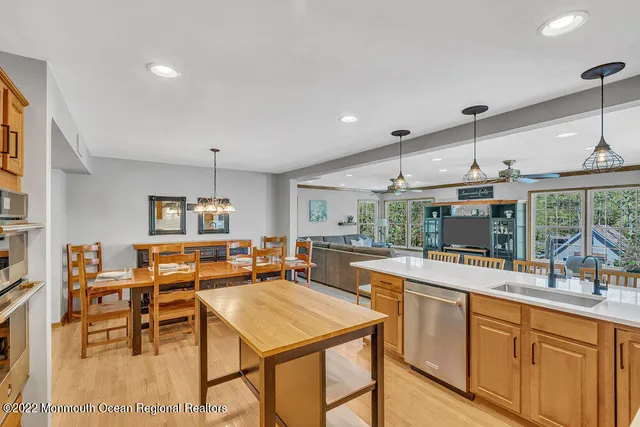 a open kitchen with stainless steel appliances granite countertop a table and chairs in it