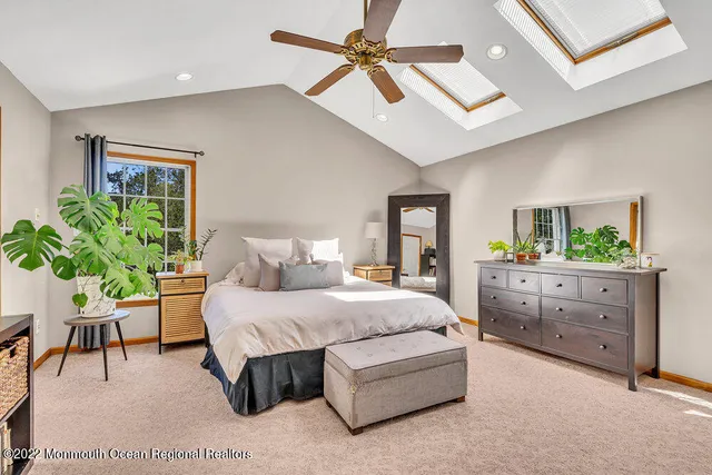 a spacious bedroom with a bed a window and a flat screen television