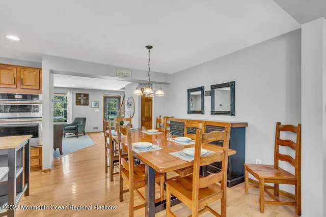 a dining room with furniture a chandelier and wooden floor