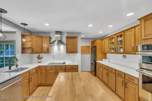 a large kitchen with stainless steel appliances granite countertop a sink and cabinets