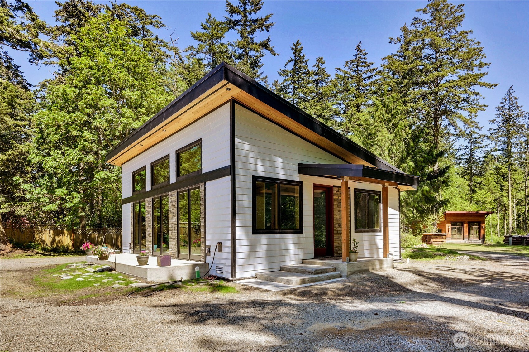 196 Nolton Road Nordland, WA 98358 - Photo 2 of 39 a front view of a house with a garden and trees