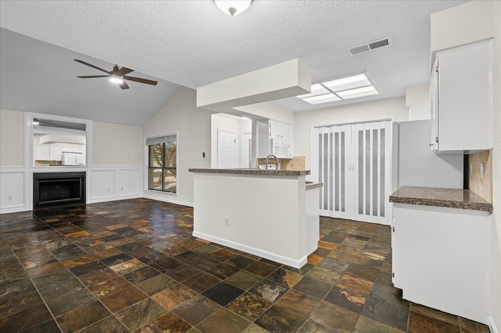 361 Fantail Loop, Unit B Austin, TX 78734 - Photo 11 of 29 a view of a kitchen with an empty space and a fireplace