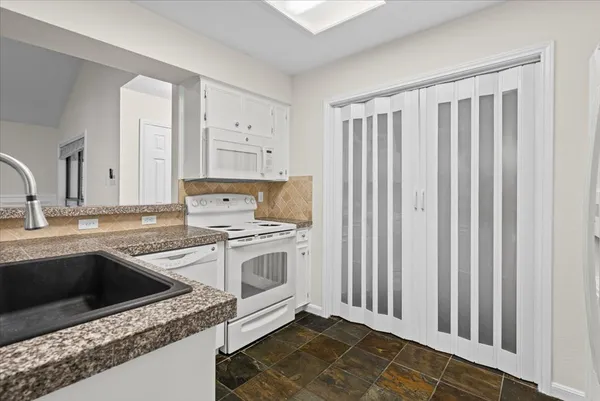a kitchen with a sink stove and cabinets