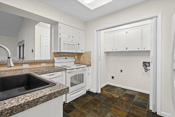a kitchen with granite countertop a sink stainless steel appliances and cabinets