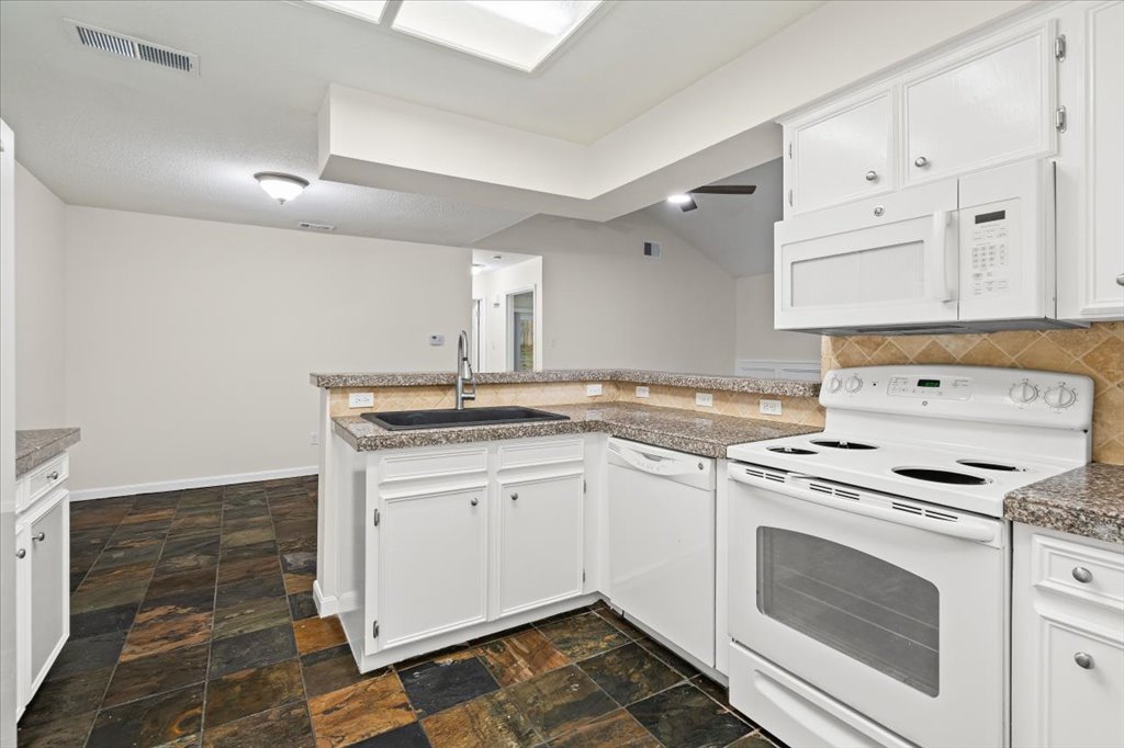 361 Fantail Loop, Unit B Austin, TX 78734 - Photo 15 of 29 a kitchen with granite countertop a sink stainless steel appliances and cabinets