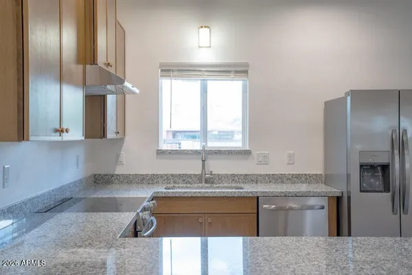 a kitchen with granite countertop stainless steel appliances granite countertop a sink stove and cabinets