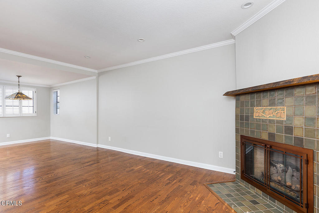249 Alpine Street, Unit 44 Pasadena, CA 91106 - Photo 6 of 23 a view of an empty room with wooden floor and a fireplace