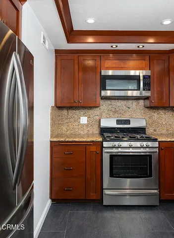 a kitchen with stainless steel appliances granite countertop a sink stove and microwave