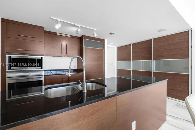 a view of a livingroom with entryway flat screen tv wooden shelves and closet