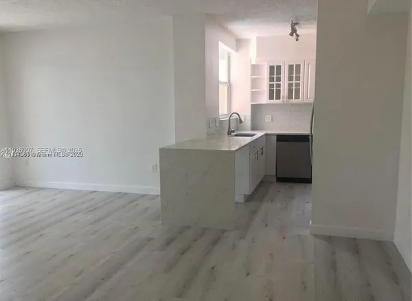 a room with a sink cabinets and wooden floor