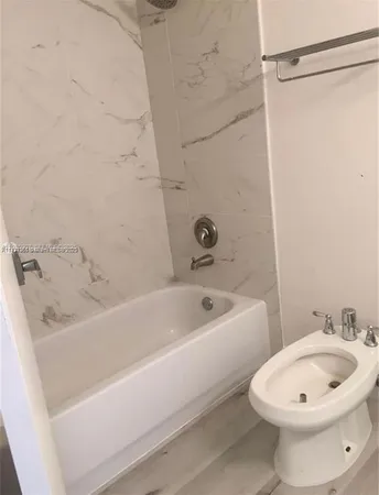a bathroom with a white bath tub a sink and a toilet