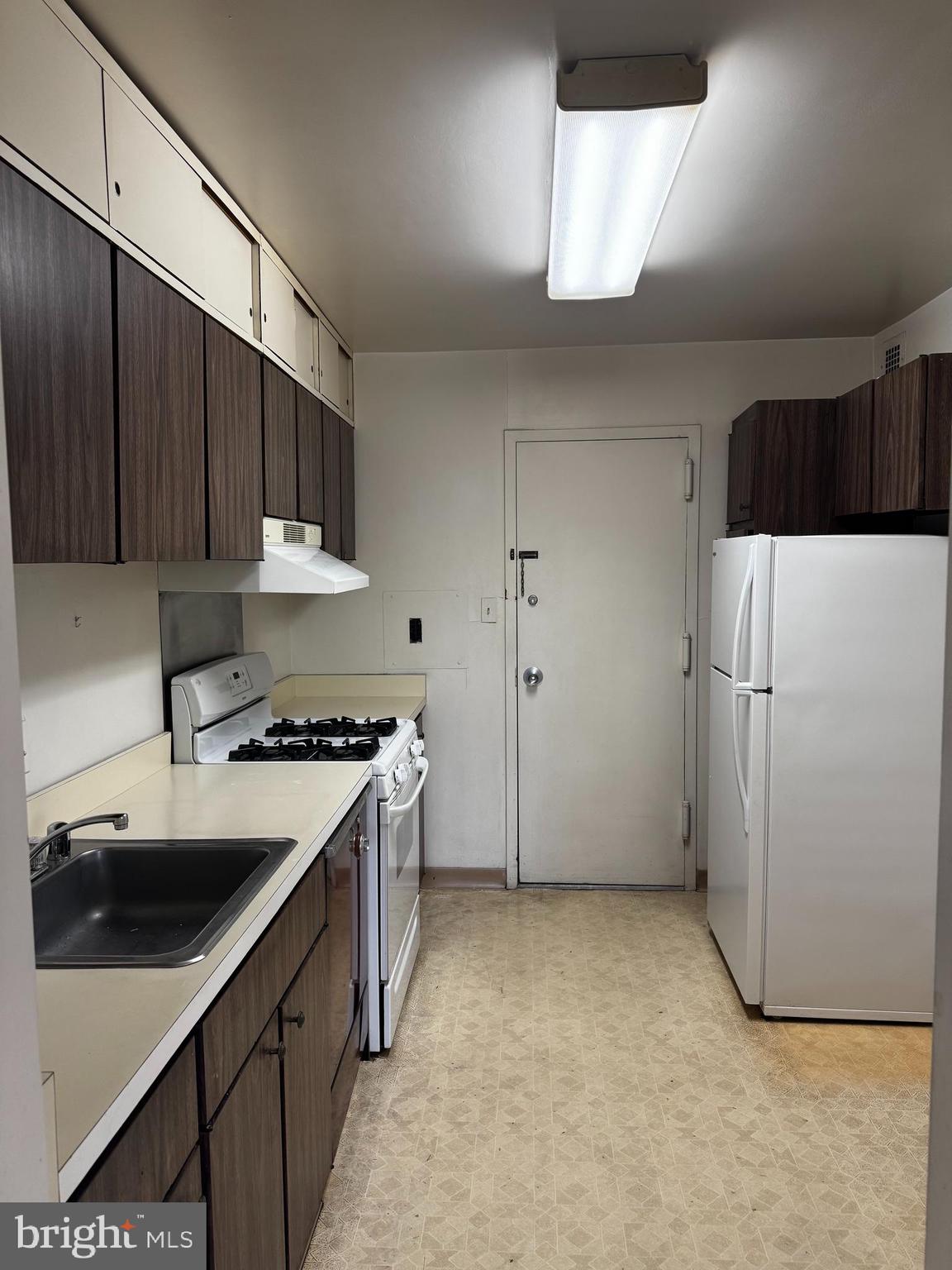 1111 University Boulevard West, Unit 402 Silver Spring, MD 20902 - Photo 5 of 15 a kitchen with a sink a stove and refrigerator