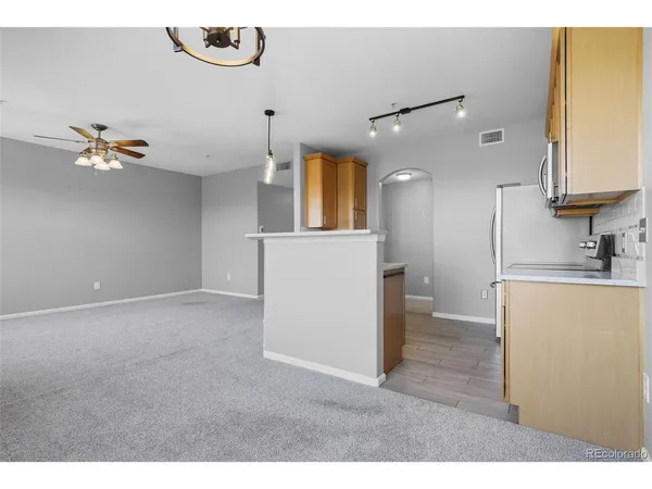 a kitchen with kitchen island a refrigerator and a sink