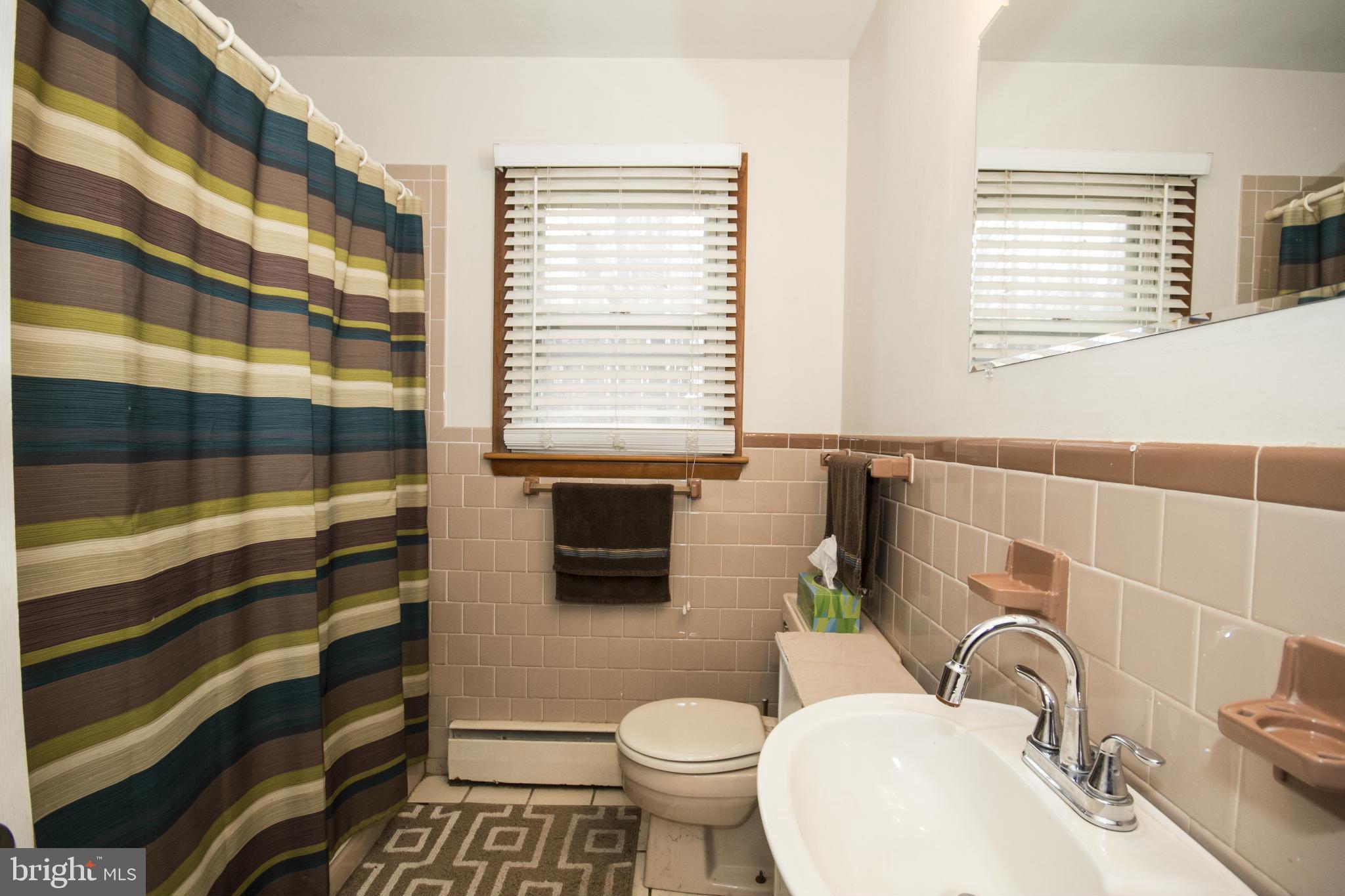 5024 Kemp Road Reisterstown, MD 21136 - Photo 11 of 30 a bathroom with a sink a toilet and shower curtain