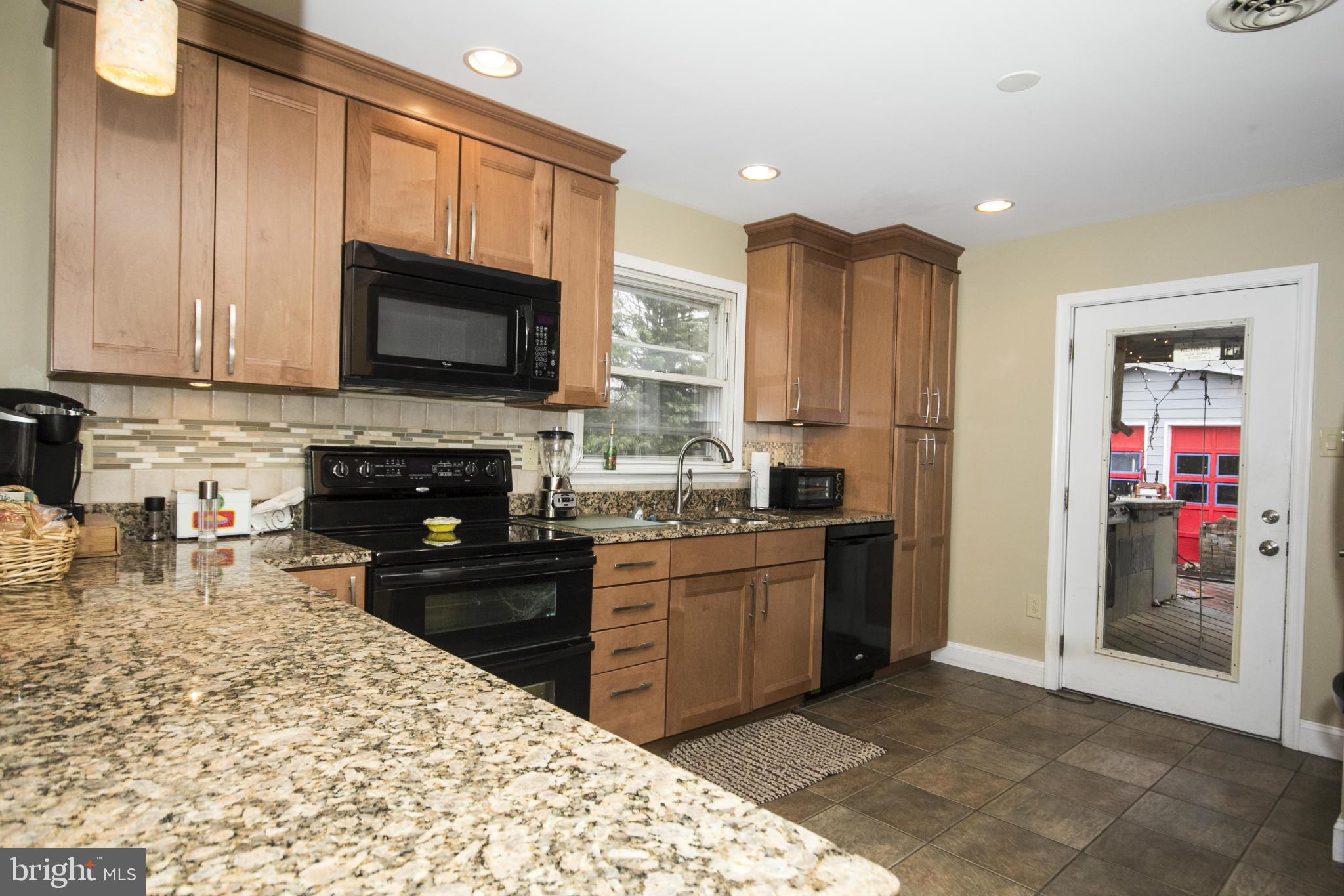 5024 Kemp Road Reisterstown, MD 21136 - Photo 7 of 30 a kitchen with stainless steel appliances granite countertop a stove sink microwave and cabinets