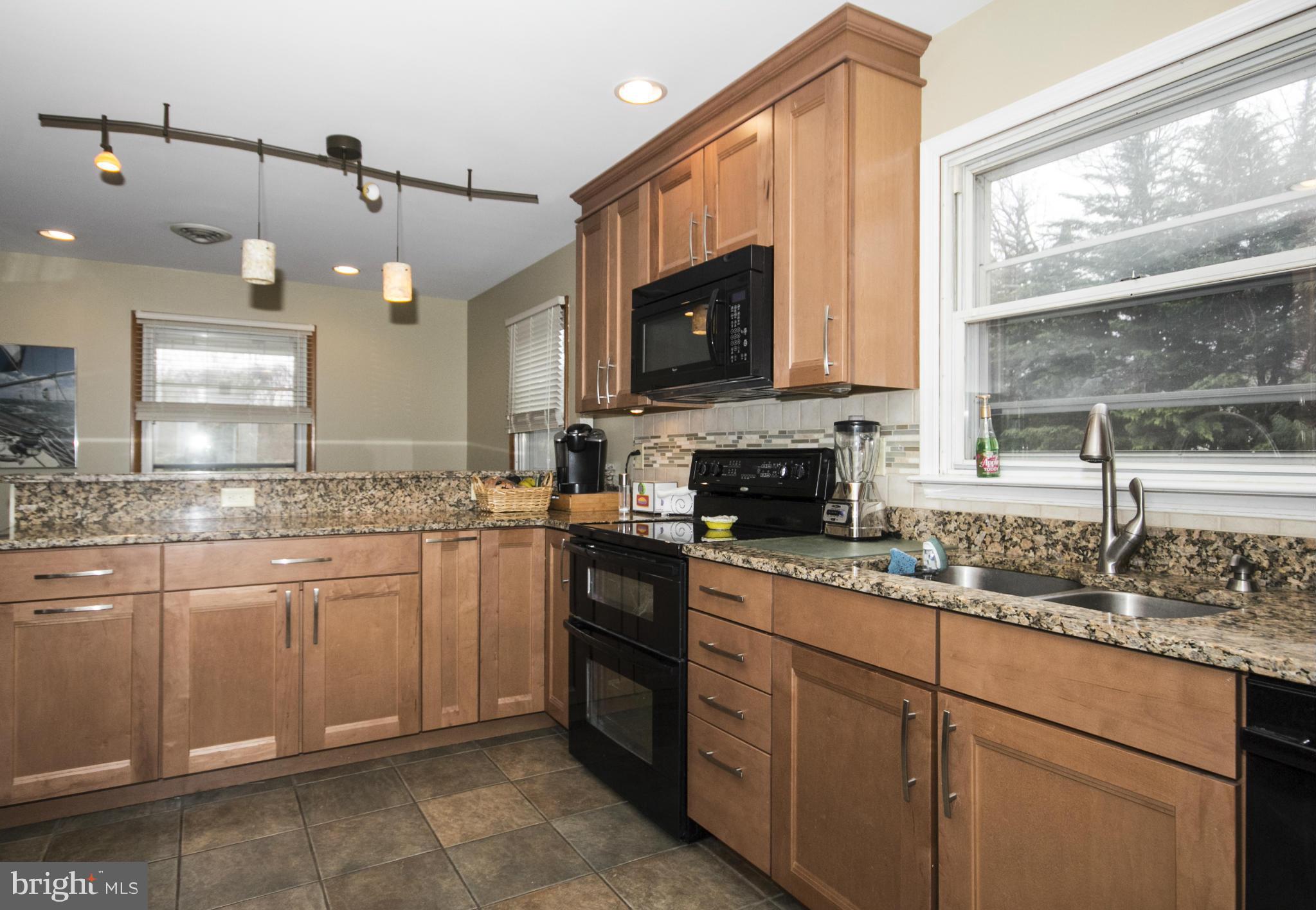 5024 Kemp Road Reisterstown, MD 21136 - Photo 8 of 30 a kitchen with stainless steel appliances granite countertop a sink a stove a microwave a counter space and cabinets