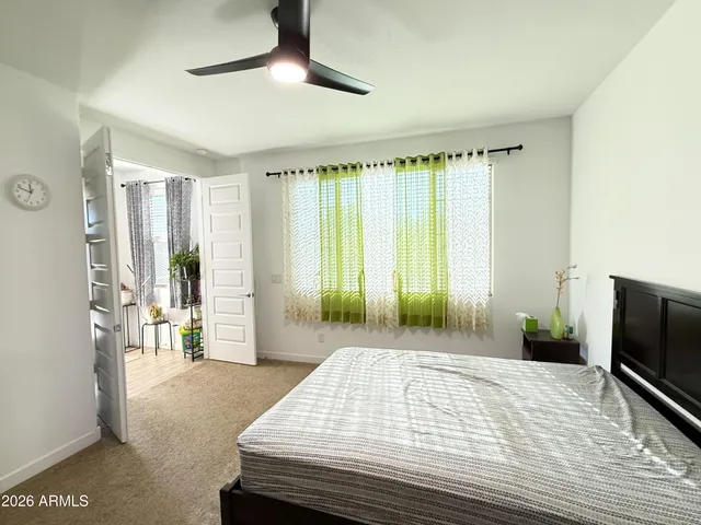 a bedroom with a bed and large windows