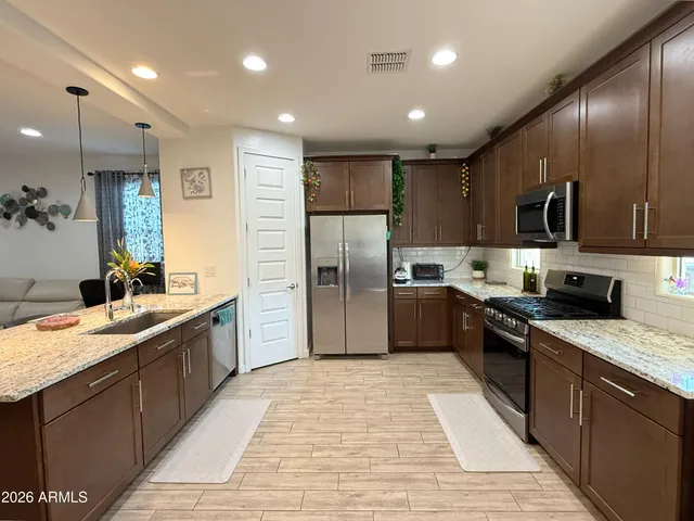 a large kitchen with stainless steel appliances kitchen island granite countertop a sink counter space cabinets and a center island