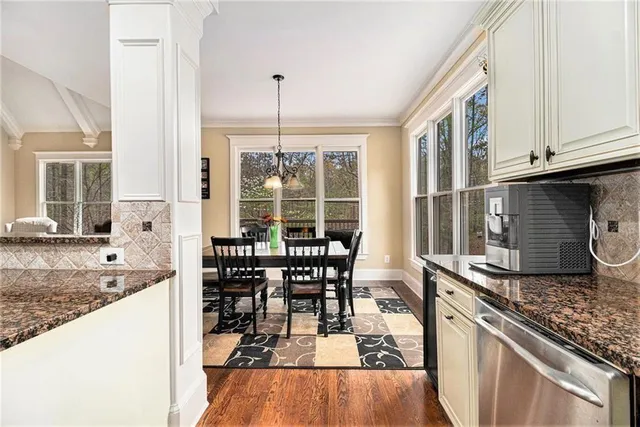 a large kitchen with granite countertop a stove a sink a refrigerator a center island and cabinets