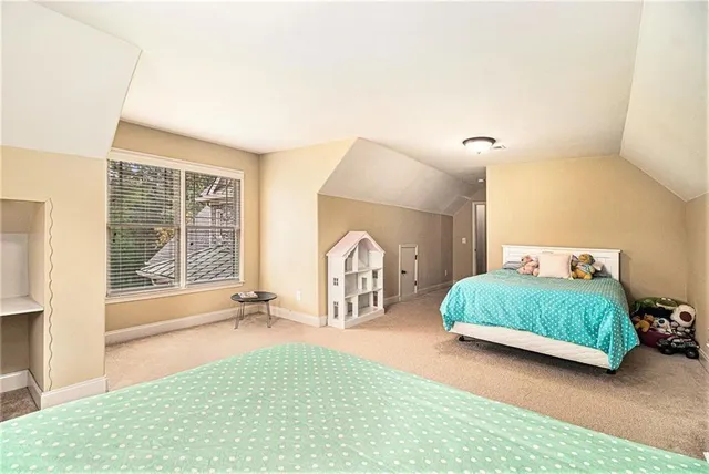 a bedroom with a bed and a flat tv screen on dresser