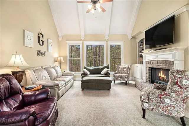 a living room with furniture a fireplace and a flat screen tv