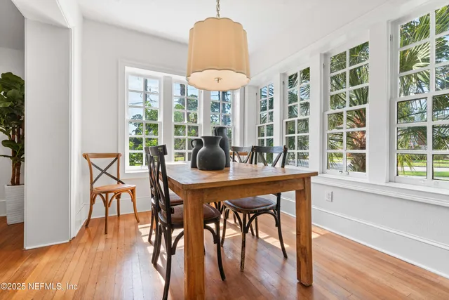 a dining room with furniture a chandelier and wooden floor