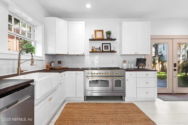 a kitchen with stainless steel appliances granite countertop a stove and white cabinets