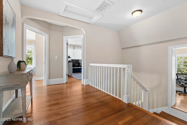 a view of a hallway with wooden floor and staircase