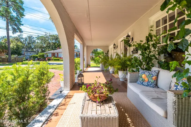 a view of a patio with couches table and chairs and potted plants
