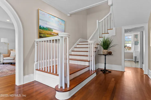 a view of a hallway with wooden floor and stairs