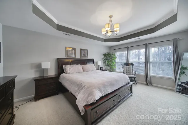 a spacious bedroom with a bed and a chandelier