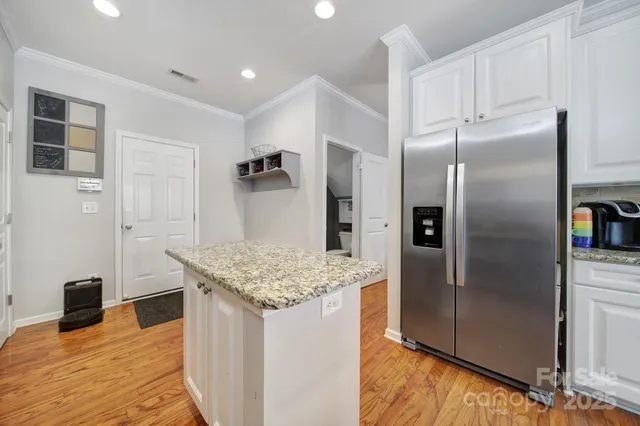 a kitchen with stainless steel appliances granite countertop a refrigerator and a sink