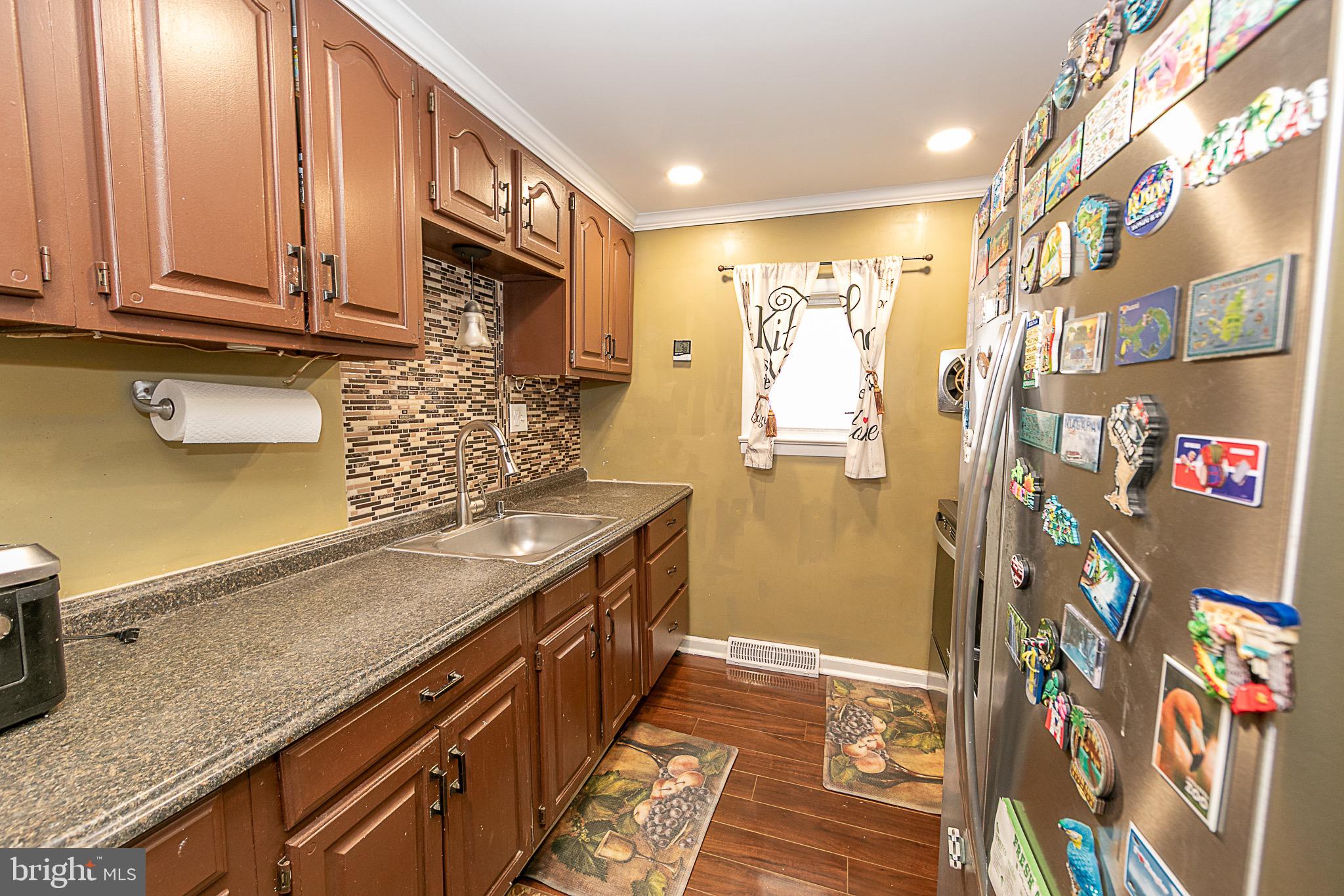287 Jefferson Street Carneys Point, NJ 08069 - Photo 15 of 31 a kitchen with stainless steel appliances granite countertop a refrigerator a stove and a sink with wooden floor
