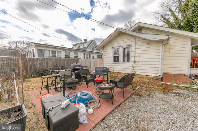 a backyard of a house with fire pit and chairs