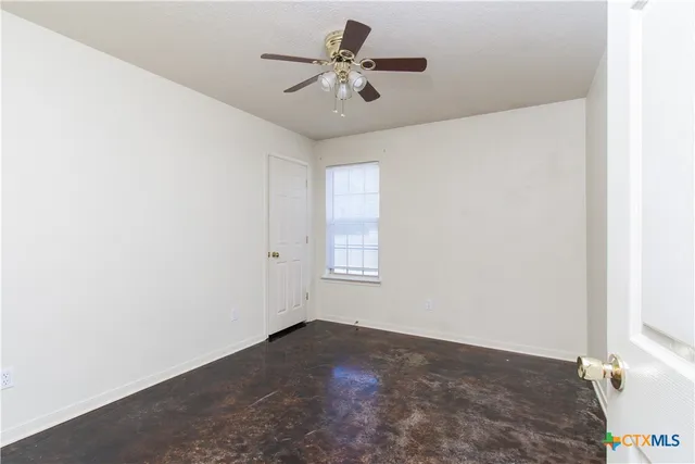a view of empty room with ceiling fan