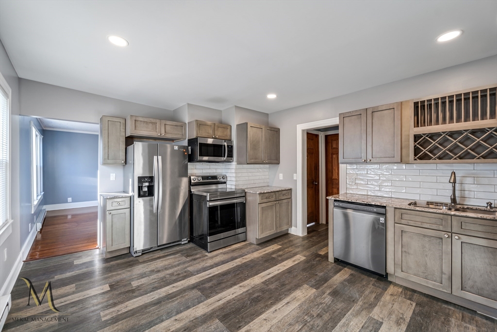 19-21 Daniel Street, Unit 19 Springfield, MA 01151 - Photo 4 of 26 a kitchen with stainless steel appliances a stove a sink and a refrigerator