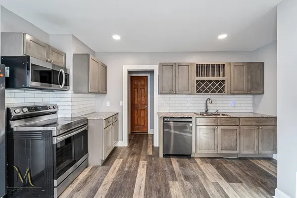 a kitchen with stainless steel appliances granite countertop a stove top oven and sink