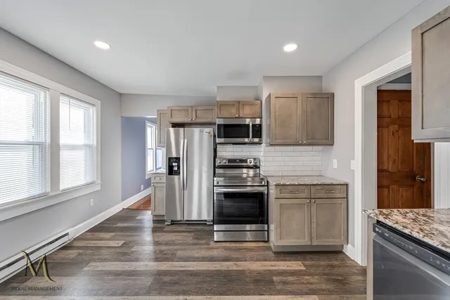 a kitchen with stainless steel appliances granite countertop a stove a refrigerator and a sink