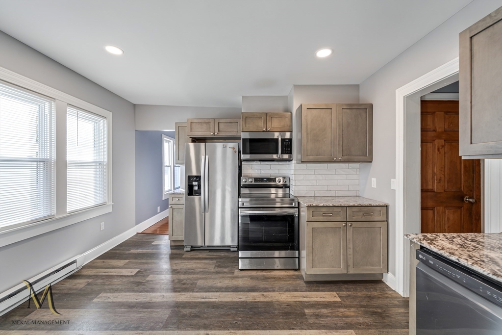 19-21 Daniel Street, Unit 19 Springfield, MA 01151 - Photo 6 of 26 a kitchen with stainless steel appliances granite countertop a stove a refrigerator and a sink