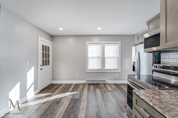 a kitchen with a wooden floor and a large window