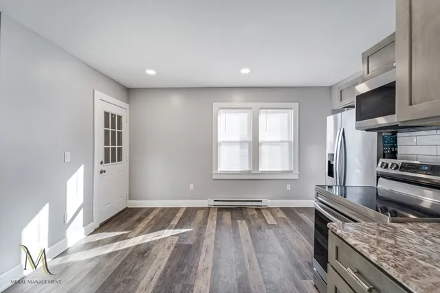 a kitchen with a wooden floor and a large window