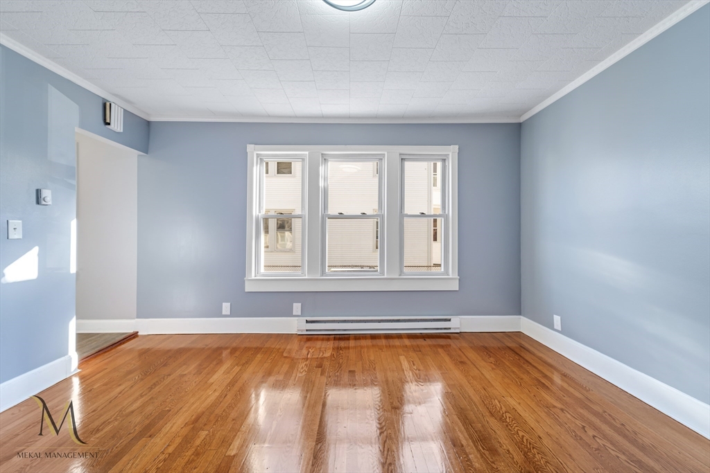 19-21 Daniel Street, Unit 19 Springfield, MA 01151 - Photo 10 of 26 a view of an empty room with window and wooden floor