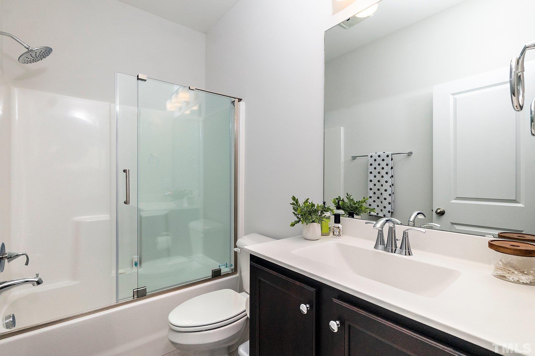821 Malta Way Durham, NC 27703 - Photo 23 of 30 a bathroom with a sink a toilet and shower