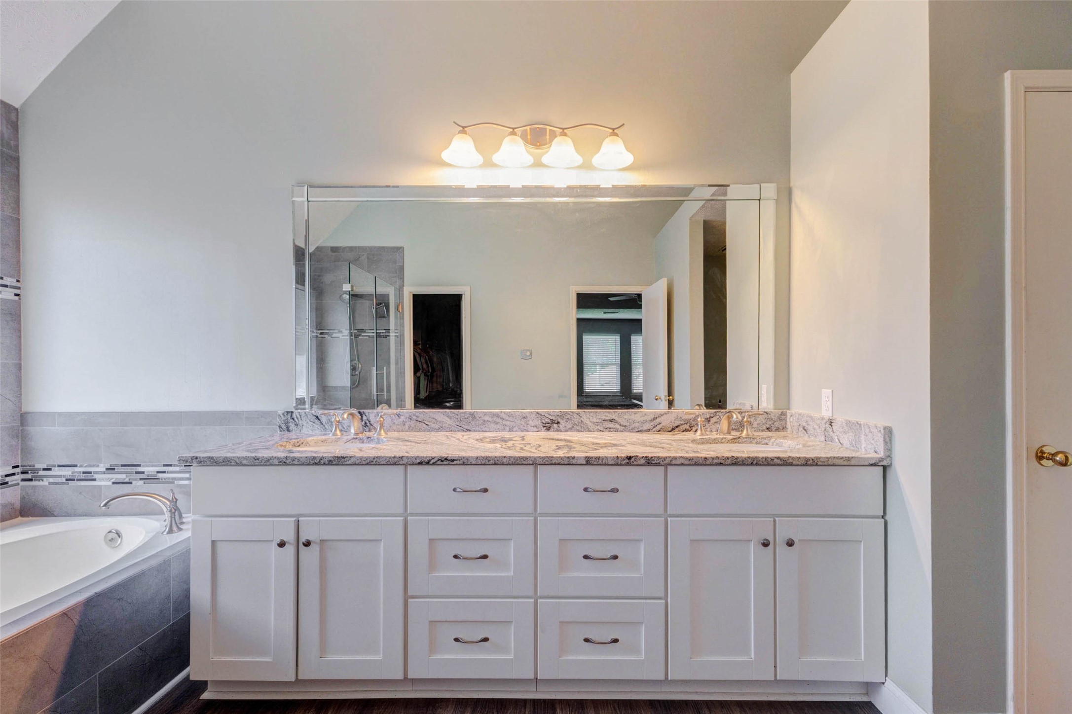 9215 Landry Boulevard Spring, TX 77379 - Photo 28 of 42 The spacious vanity area features white cabinetry with abundant drawer storage, granite countertops, dual sinks, nickel fixtures, and a full length mirror.